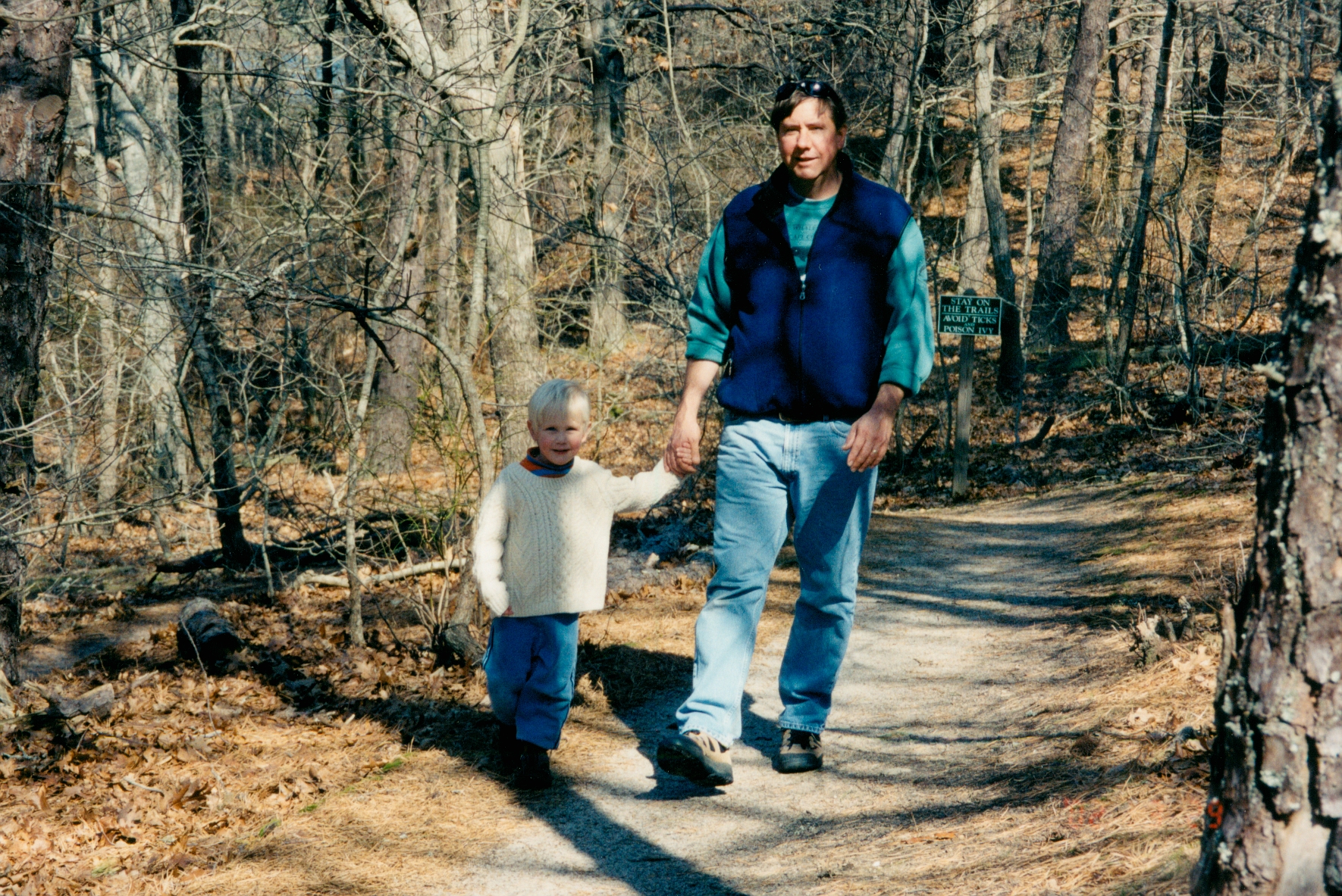 Grandfather sitting on the floor with arm around grandchild, reading together