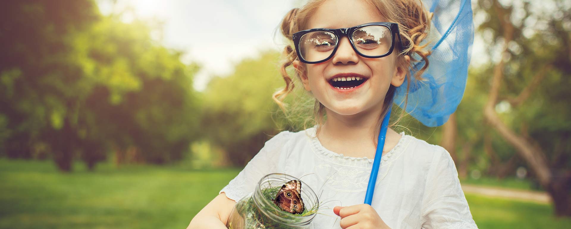 girl-with-butterfly-and-net girl smiling with butterfly in a jar and a net over her shoulder